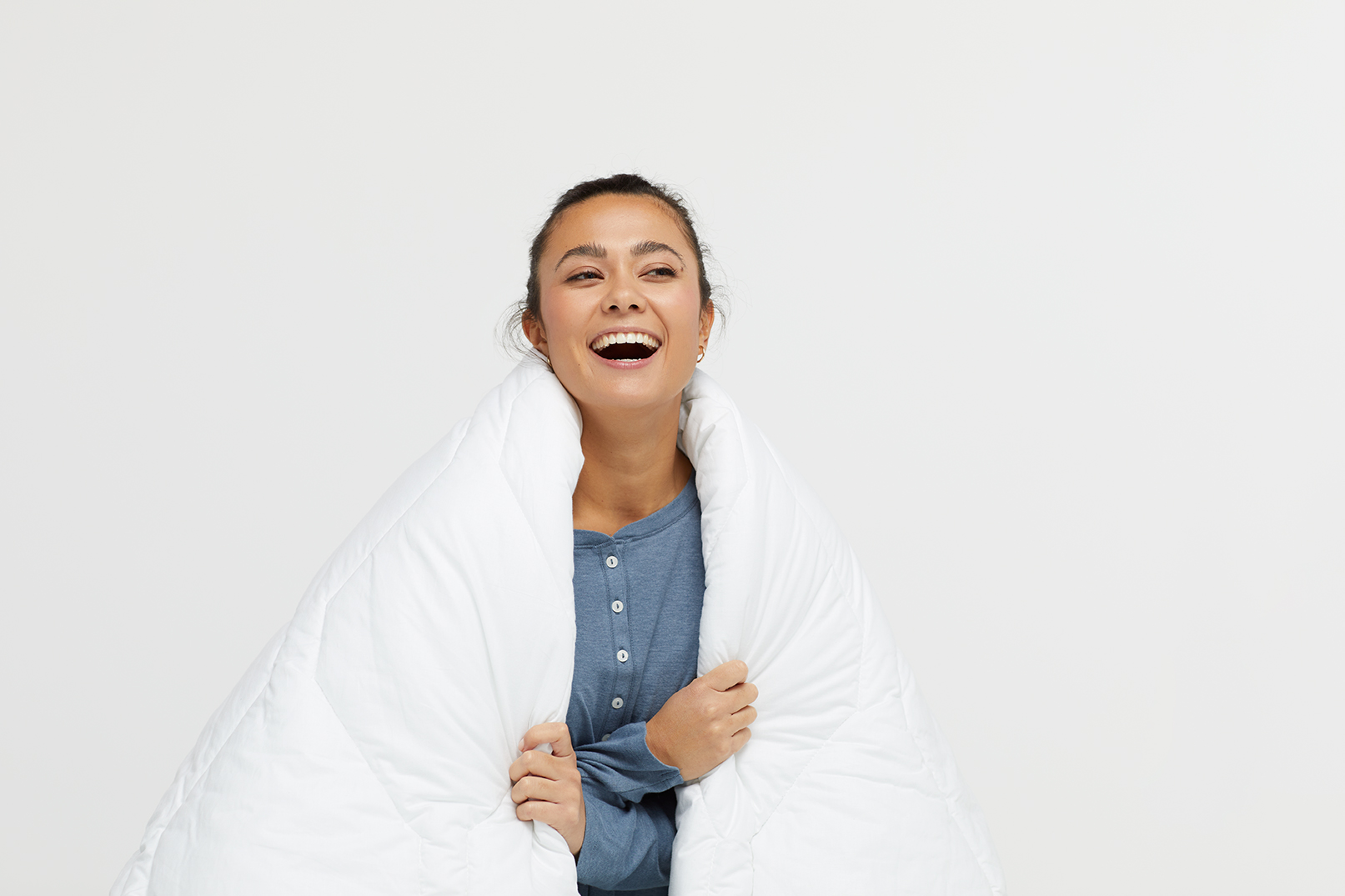 Model with bedding over her shoulders.