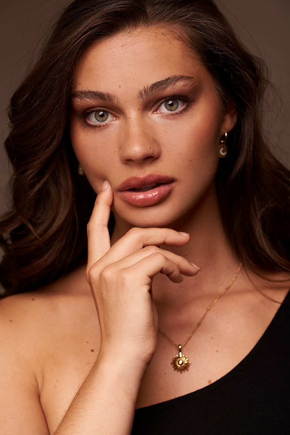 Dark haired model showing a necklace