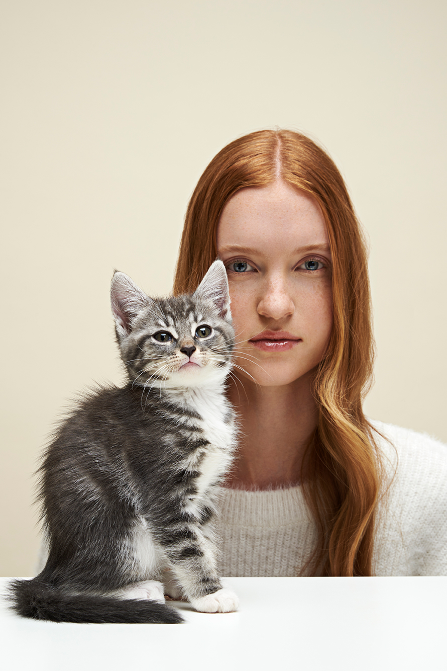 Model sitting with a kitten in front of her